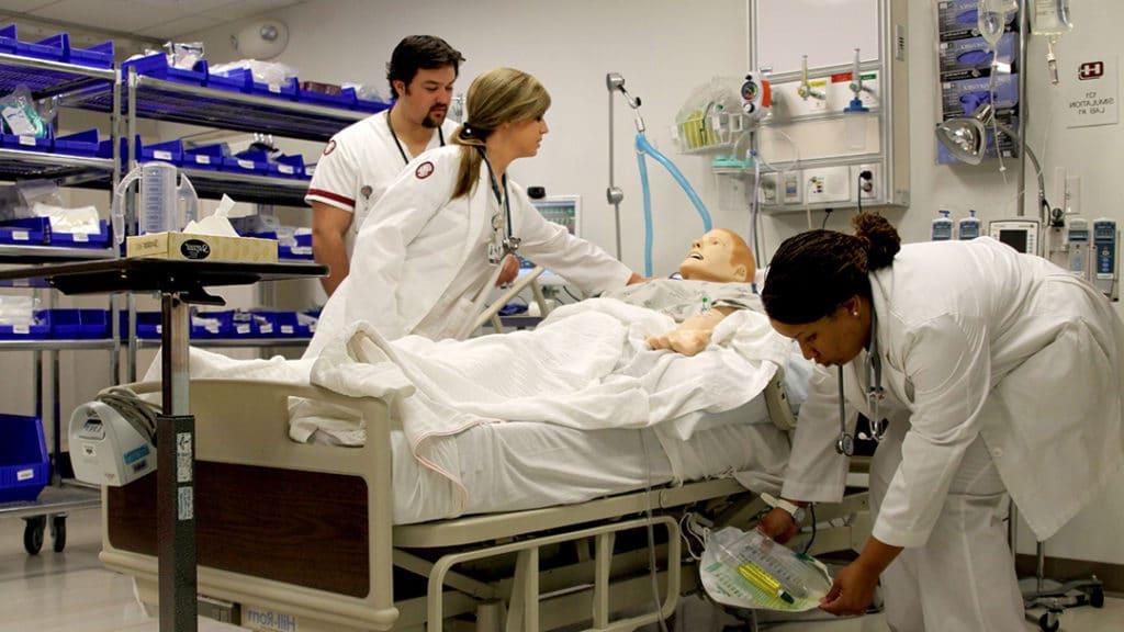三个护生正在照顾一个模拟病人